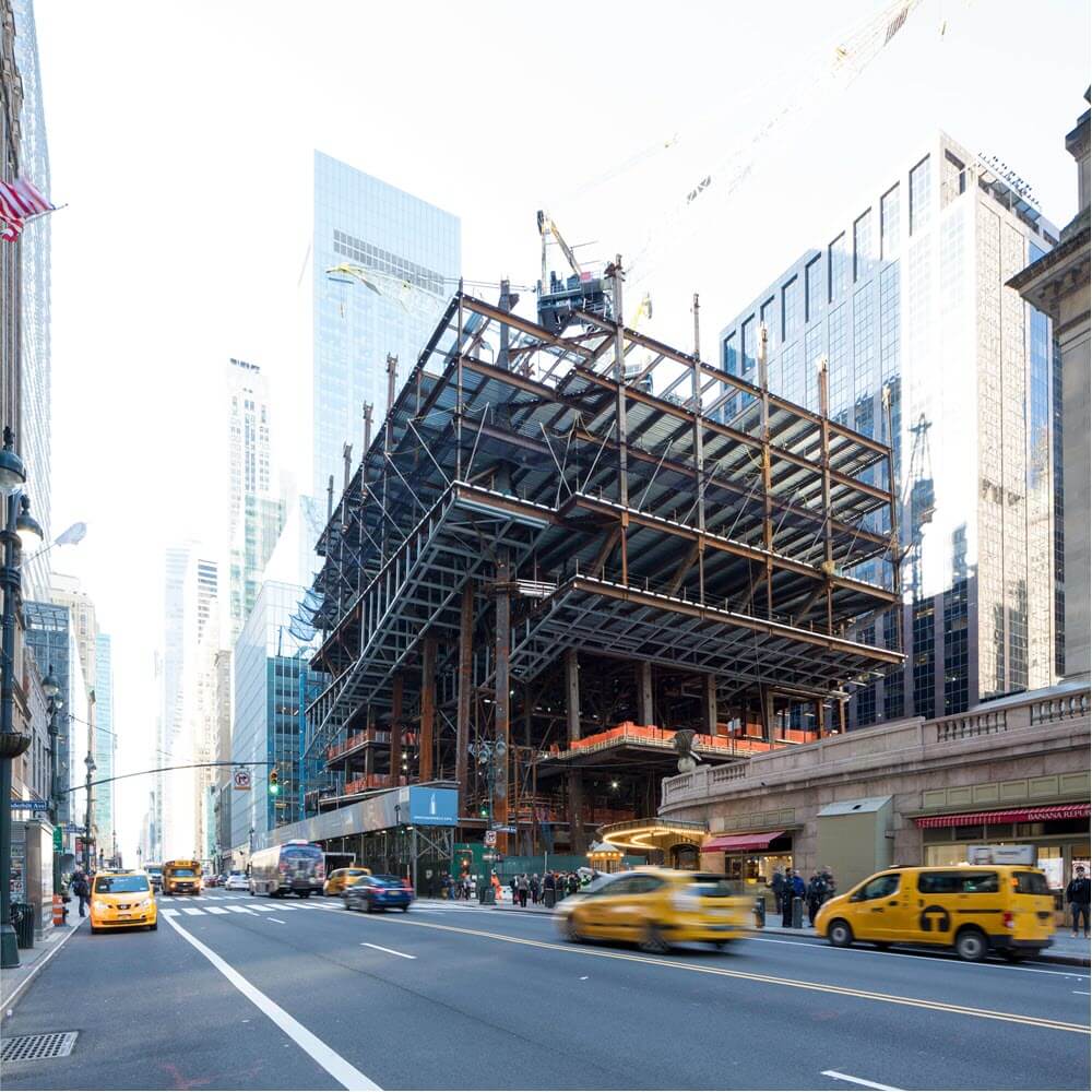 Structural steel frames out the lower floors above the avenue