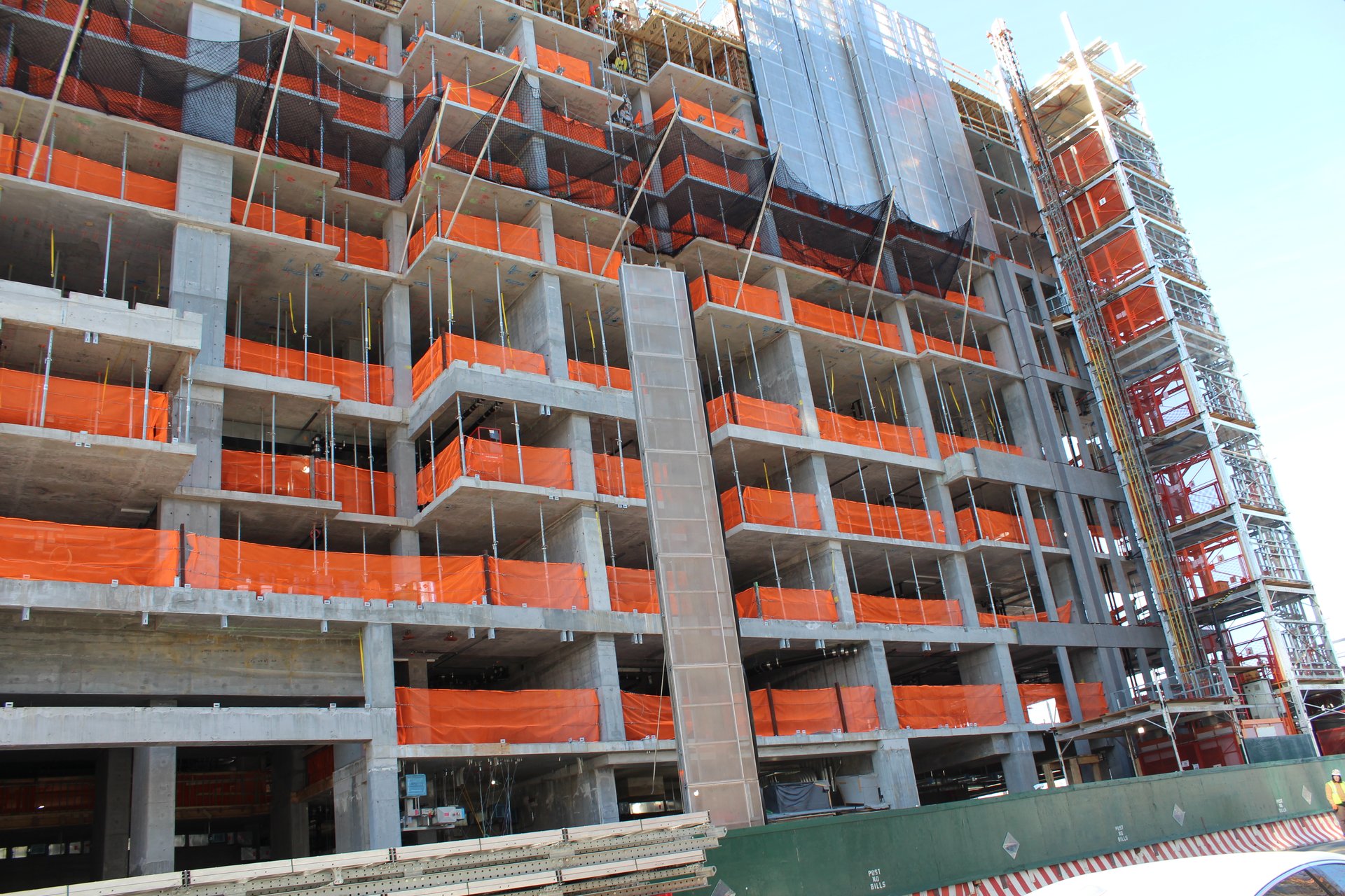 The concrete frame rises with perimeter netting in place