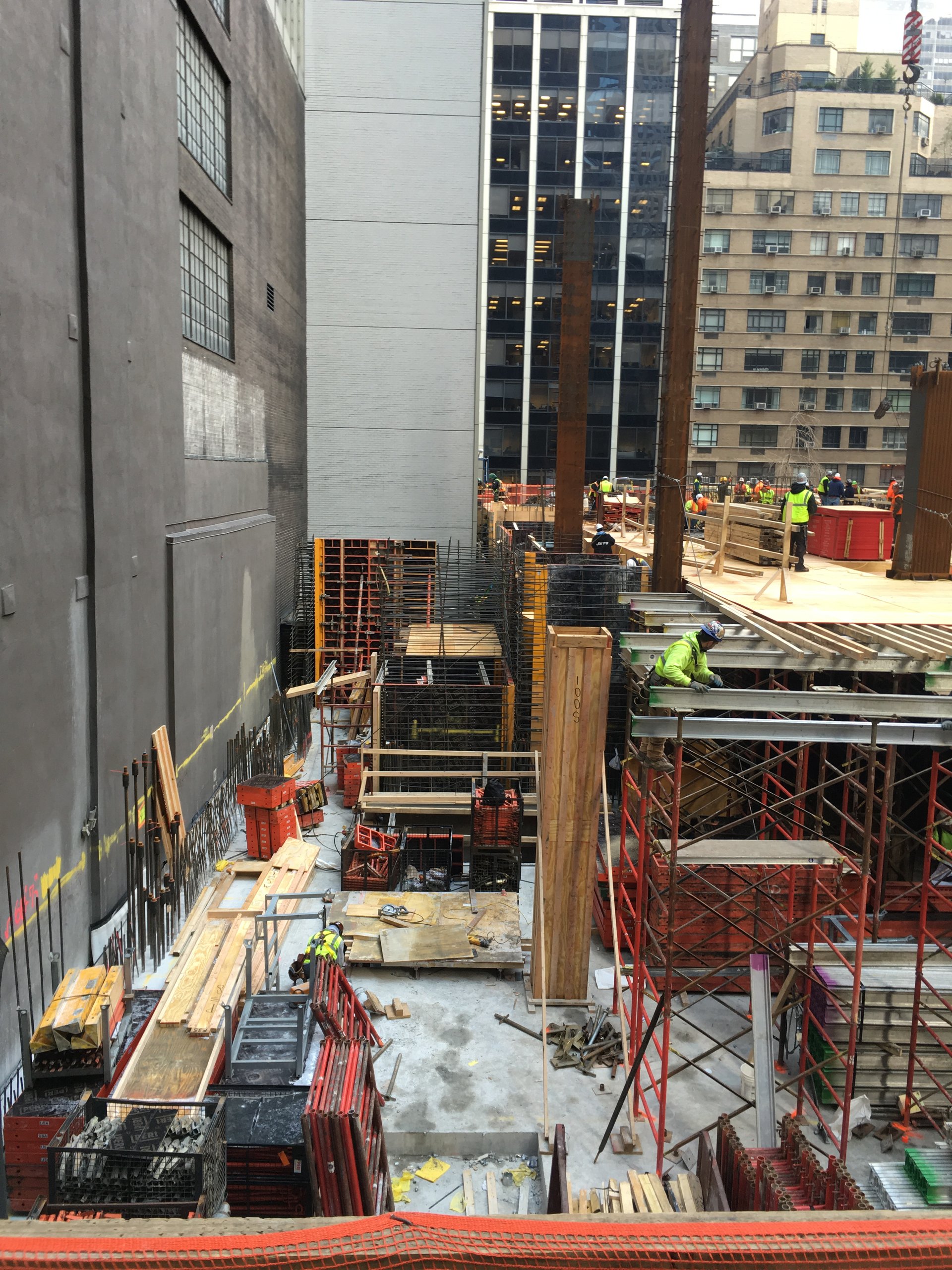 Column rebar cages and wall forms rise from the base