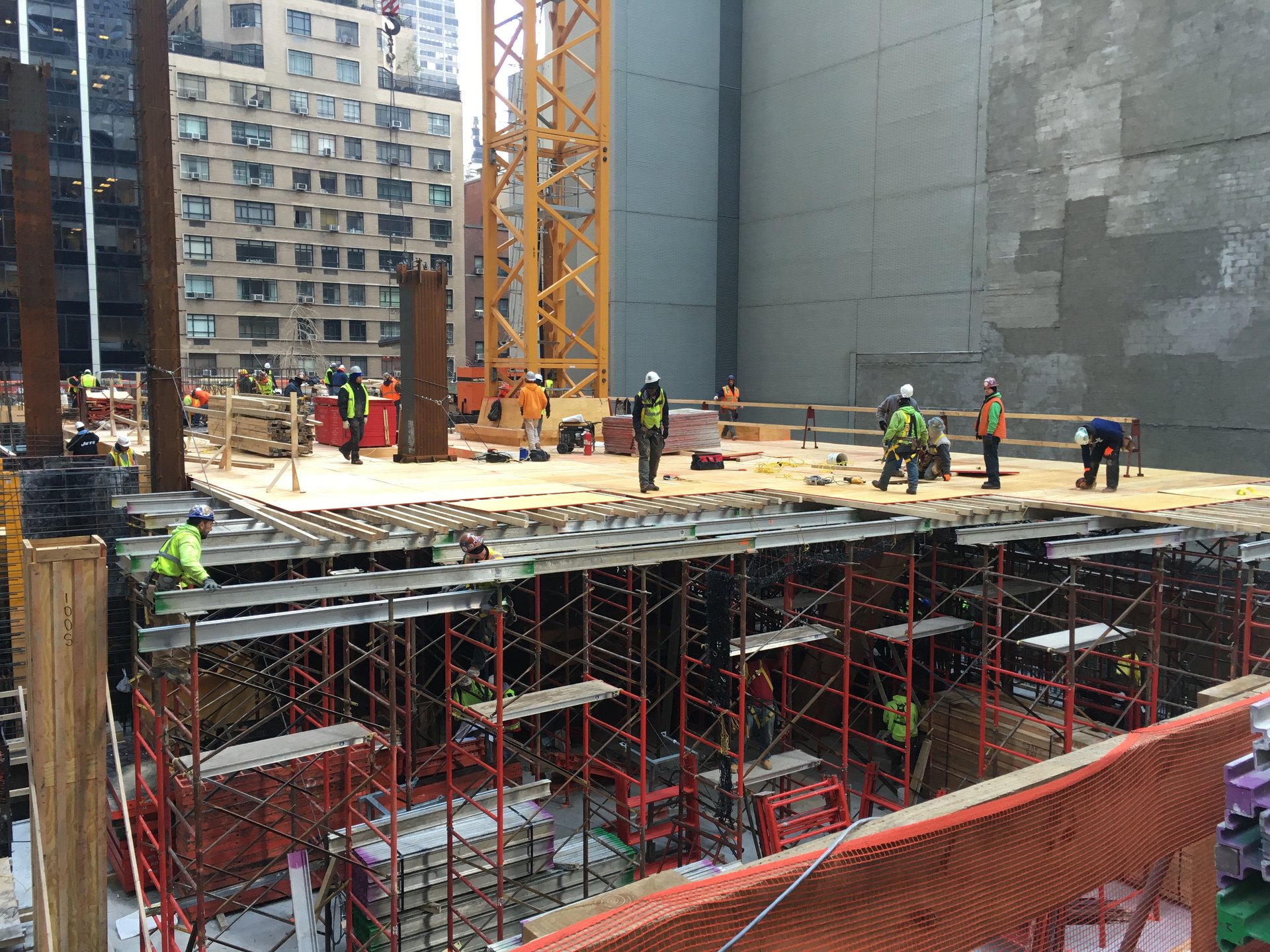 Crews at the formed deck edge between neighboring buildings
