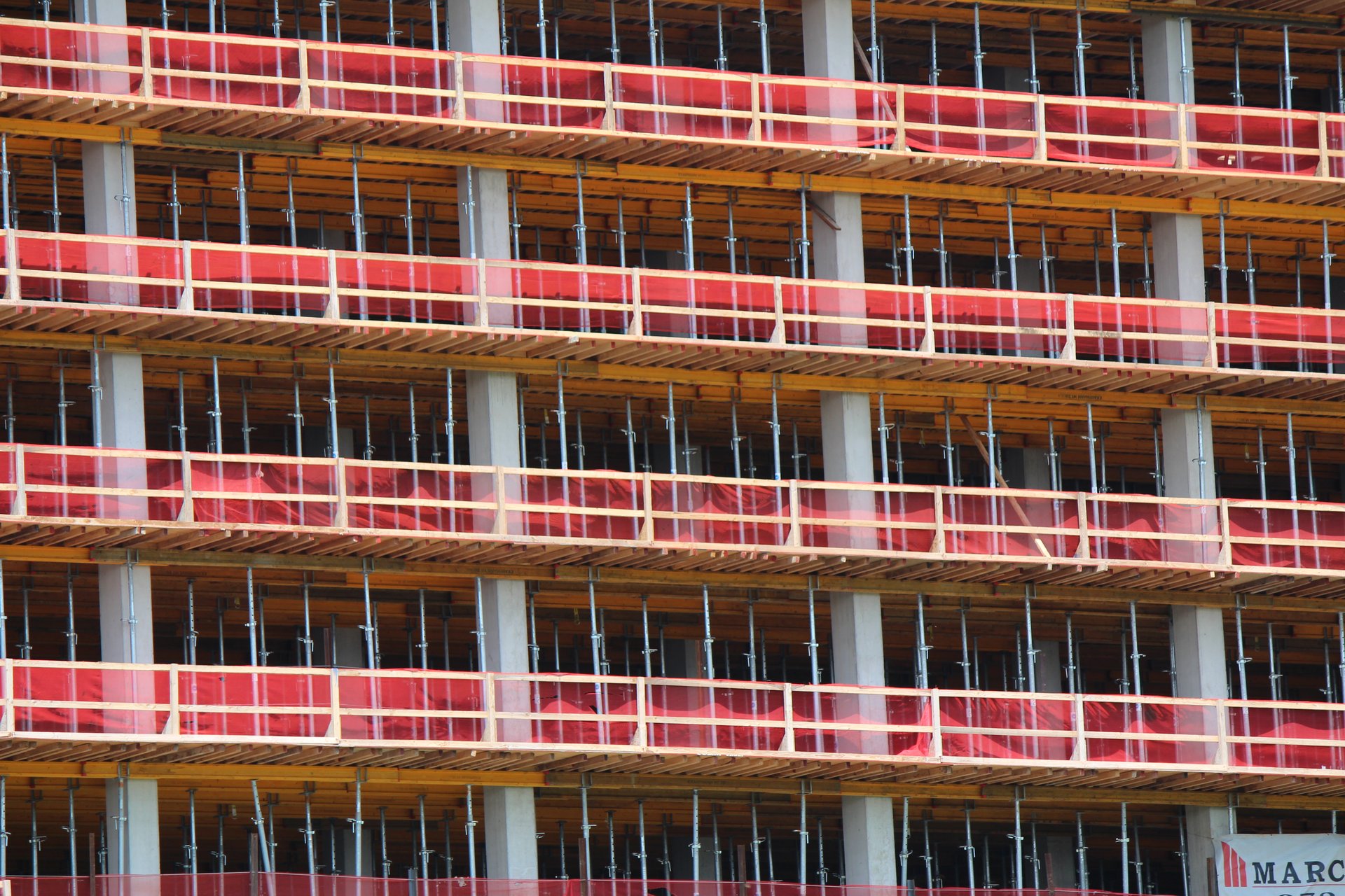 Rows of post shores and perimeter guardrails across the building face