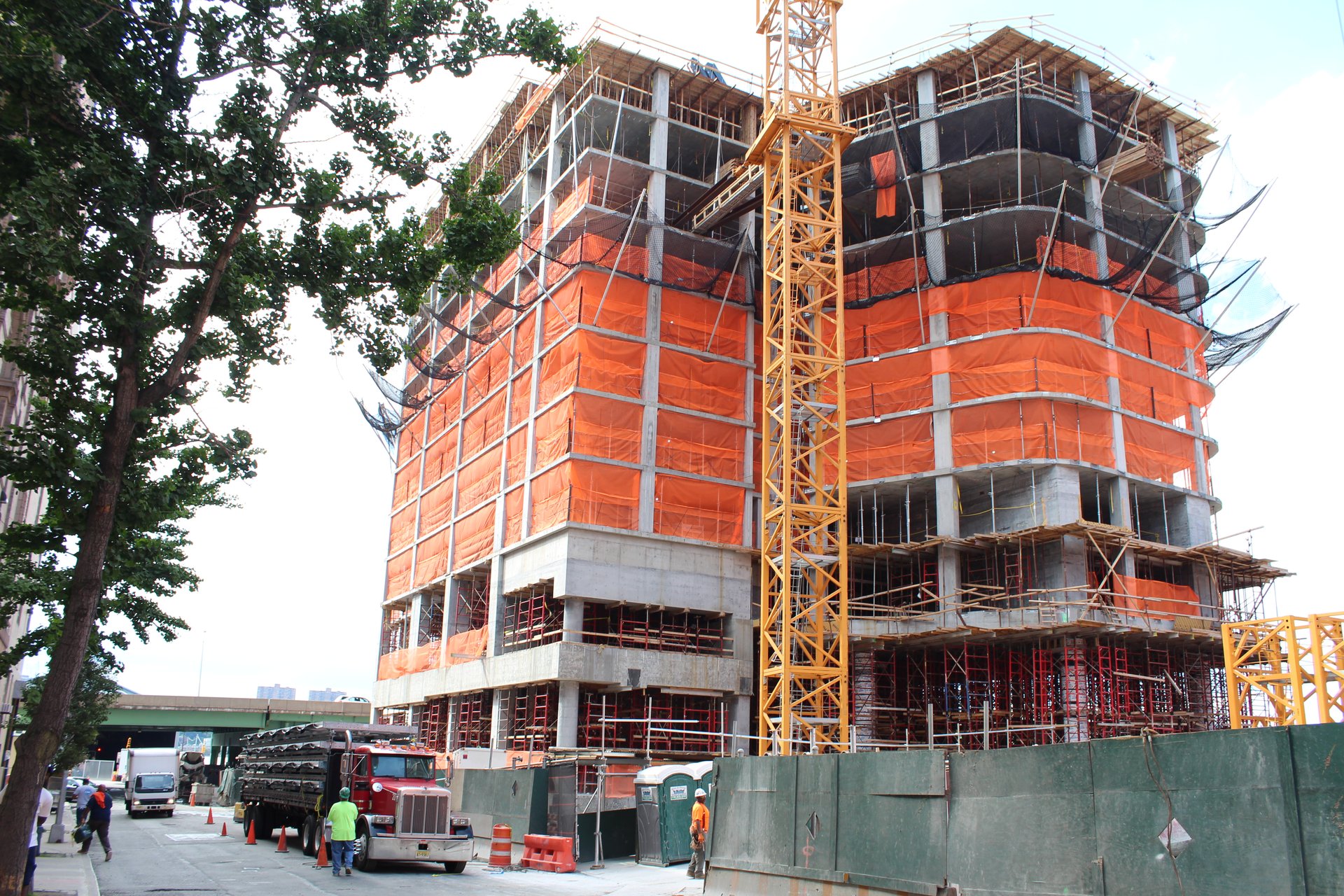 Formwork and perimeter protection track the tower's curved slab edges